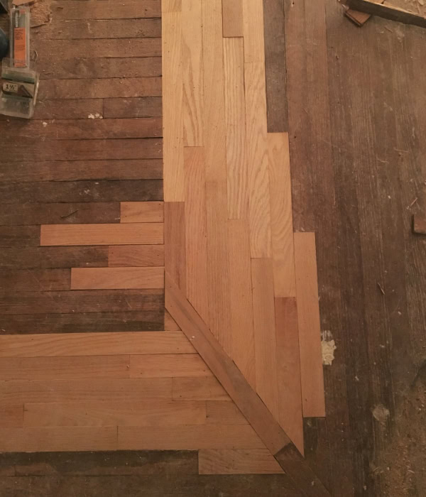 Old narrow-strip oak flooring that has been patched with new pieces