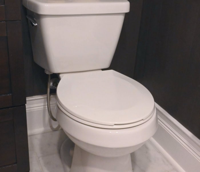 Closeup of bathroom toilet installed in newly renovated bathroom.