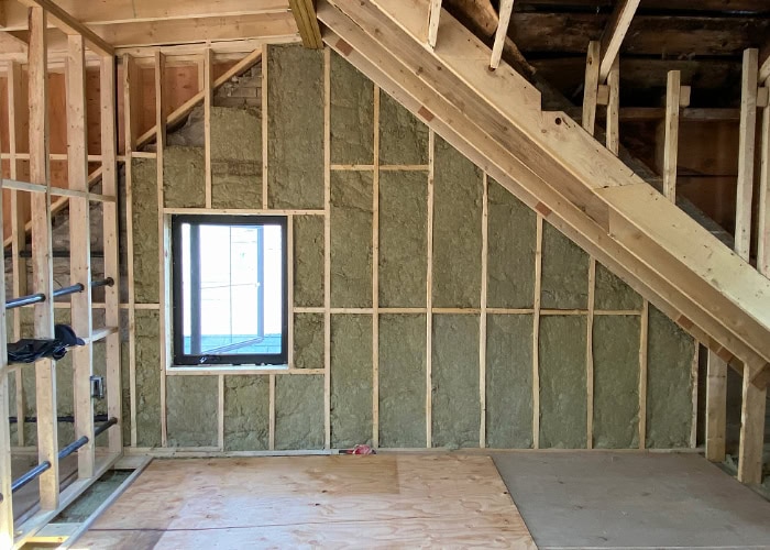 Replacing the insulation in the walls of an old home with new Roxul insulation.