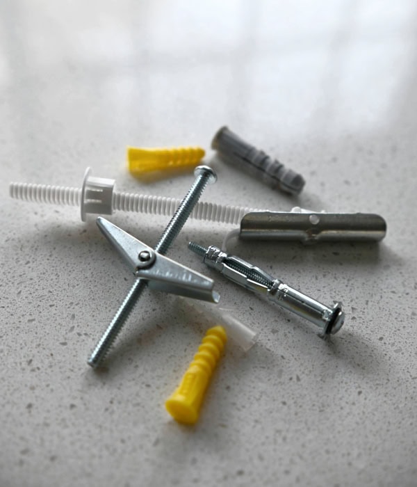 A small pile of wall anchors, toggle bolts and molly bolts. These should not be used to hang shelves on plaster walls, unless there is masonry behind the plaster. 